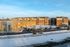 Charming residential complex with modern architecture, featuring a snow-covered landscape and ample parking.