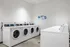 Modern laundry room with multiple high-efficiency washers and dryers, offering convenience and style.