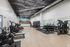 Modern fitness center with state-of-the-art exercise equipment, sleek design, and vibrant cityscape mural enhancing the workout ambiance.