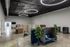 Modern co-working space with sleek circular lighting, cozy seating pods, and ample natural elements, promoting a productive and inspiring work environment.