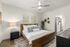 Elegant bedroom with a cozy wooden bed, stylish decor, and a chic bedside table in a modern apartment.