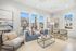 Bright and inviting living room with modern blue sofa, stylish decor, and large windows offering abundant natural light.