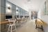 Chic co-working space with modern computers, comfortable seating, elegant lighting, and a stylish shuffleboard table.