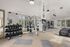 Modern fully-equipped gym with state-of-the-art fitness equipment and large windows offering a bright, invigorating workout space.
