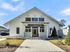 Charming clubhouse exterior with modern design, welcoming front entrance and lush landscaping.