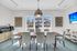 Elegant dining room with a modern table set for six under a stylish pendant light, featuring a scenic window view, a coffee bar, and contemporary decor.