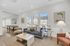 Elegant living room with chic decor, featuring large windows, modern furniture, and a pool view.