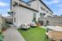 Charming outdoor space with cozy seating area, lush artificial grass, and modern accents; perfect for relaxation and entertaining.
