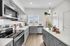 Modern kitchen with sleek gray cabinetry, stainless steel appliances, and bright natural lighting.