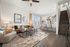 Chic open-plan living space with cozy seating, modern kitchen island with bar stools, and elegant decor, perfect for stylish entertaining.