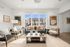 Bright and inviting living room with modern seating, decorative artwork, and large windows overlooking a charming courtyard.