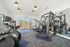 Bright and modern fitness center featuring state-of-the-art exercise equipment and large windows for natural light.