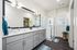 Bright, modern bathroom featuring a sleek double sink vanity, glass shower, and chic decor accents.