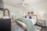 Bright and inviting bedroom with a cozy bed, decorative pillows, stylish lighting, and elegant coastal accents.