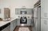 Chic modern kitchen with sleek stainless steel appliances, elegant pendant lighting, and ample cabinetry in a stylish apartment setting.