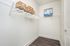 Spacious walk-in closet with stylish shelving, hangers, and chic decor baskets, perfect for organized living.