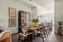 Charming dining area with a wooden table, stylish chairs, and modern kitchen in a sunlit, open-concept apartment.