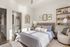 Bright and stylish bedroom with modern decor, a cozy bed, and a glimpse of an en-suite bathroom, creating a welcoming and serene atmosphere.