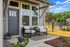 Charming outdoor patio with cozy seating, modern decor, and lush garden views, perfect for relaxation.