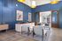 Modern apartment lobby with elegant blue paneling, contemporary seating, and stylish lighting fixtures.