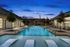 Luxurious swimming pool area with elegant lounge chairs and vibrant evening sky, perfect for relaxation and leisure.