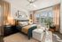 Bright and inviting bedroom with a cozy atmosphere, featuring large windows with sunlight streaming through sheer curtains, a plush bed with elegant bedding, and stylish decor accents.