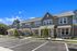 Charming townhouses with modern architecture, featuring large windows and well-kept landscaping under a vibrant blue sky.