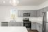 Modern kitchen with sleek gray cabinets, stainless steel appliances, and elegant countertops, creating a stylish and functional space.