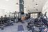 Modern, well-lit fitness center with state-of-the-art equipment, large windows, and stylish lighting fixtures.