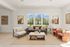 Bright and modern living room with stylish furniture, large windows, and a scenic garden view.