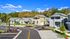 Charming modern homes nestled in a scenic community with lush greenery and vibrant landscaping, perfect for serene living.