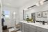 Modern bathroom with sleek glass shower, double vanity, and elegant lighting, complemented by stylish decor and plants.