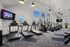 Bright and modern fitness center with state-of-the-art exercise equipment, featuring treadmills, elliptical machines, and large windows for natural light.