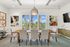 Elegant dining room with a large wooden table, comfortable chairs, and stunning garden views through wide windows.