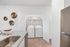 Modern kitchen featuring a sleek countertop with an integrated sink, adjacent to a convenient laundry area with washer and dryer, complete with stylish decorative wall accents.