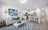 Bright open-concept living room and kitchen featuring modern decor, stylish artwork, and cozy seating.