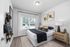 Chic bedroom with elegant decor, featuring large window, stylish wall art, and modern nightstand.