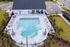 Beautiful aerial view of a luxurious pool area with sun loungers and shaded seating, perfect for relaxation and entertainment.