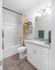 Bright and modern bathroom featuring a sleek vanity, stylish mirror, and inviting shower with vibrant yellow curtain.