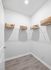 Chic walk-in closet with modern shelving and elegant wicker baskets, perfect for organized living.