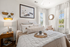 Inviting bedroom with elegant decor, featuring a plush bed, stylish wall art, and abundant natural light.