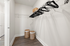 Spacious walk-in closet with elegant shelving and ample storage in a modern apartment, featuring a chic design with hardwood flooring.