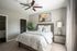 Bed in bedroom with ceiling fan