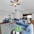Inviting open-concept living area with plush blue seating, stylish decor, and modern dining space, perfect for relaxation and entertaining.