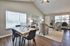 Modern open-concept living and dining area with sleek wooden floors, elegant dining table, and cozy seating arrangement in a bright and spacious room.