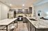 Modern kitchen with sleek granite countertops, dark wood cabinets, and stainless steel appliances, creating a sophisticated culinary space.