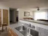 View from the kitchen sink looking into the living room with stainless steel double sink and bright natural lighting.