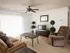 Living room with sliding glass door, ceiling fan, recliner, and entertainment setup, ideal for cozy evenings.
