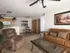 Open-concept layout showing living room and kitchen with neutral-toned furnishings and ceiling fan.