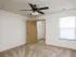 Bedroom with ceiling fan, large window, and walk-in closet in an Oak Court unit.